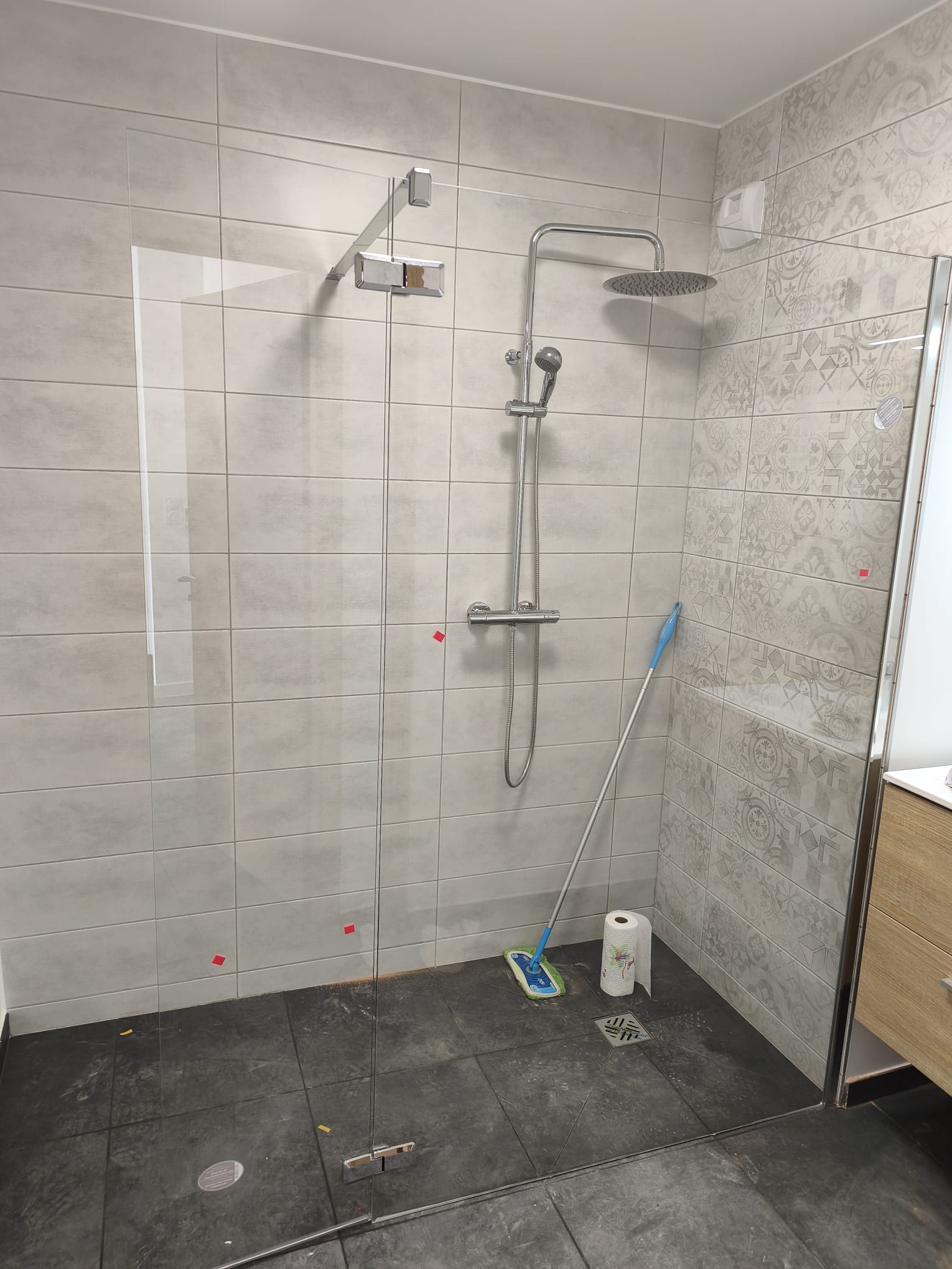 Douche à l'italienne avec faïence grise à motifs par HL Plomberie